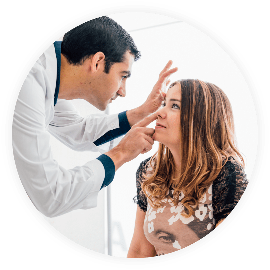 Eye care professional inspecting a patient's eye during a routine eye exam.